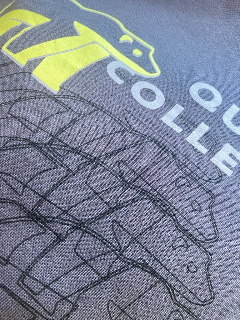 Detalle de una sudadera de la Quiddity, con el oso bordado en amarillo y el nombre de la colección